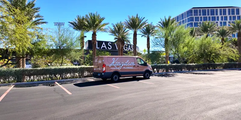 Kingdom Plumbing service van beside a Las Vegas sign lined with palm trees