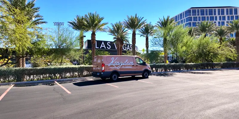 Kingdom Plumbing service van beside a Las Vegas sign lined with palm trees