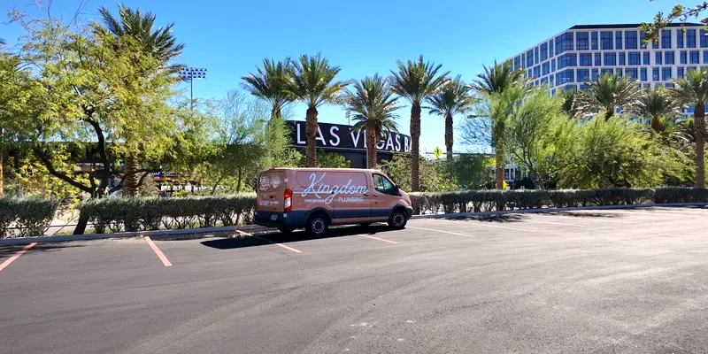 Kingdom Plumbing service van beside a Las Vegas sign lined with palm trees